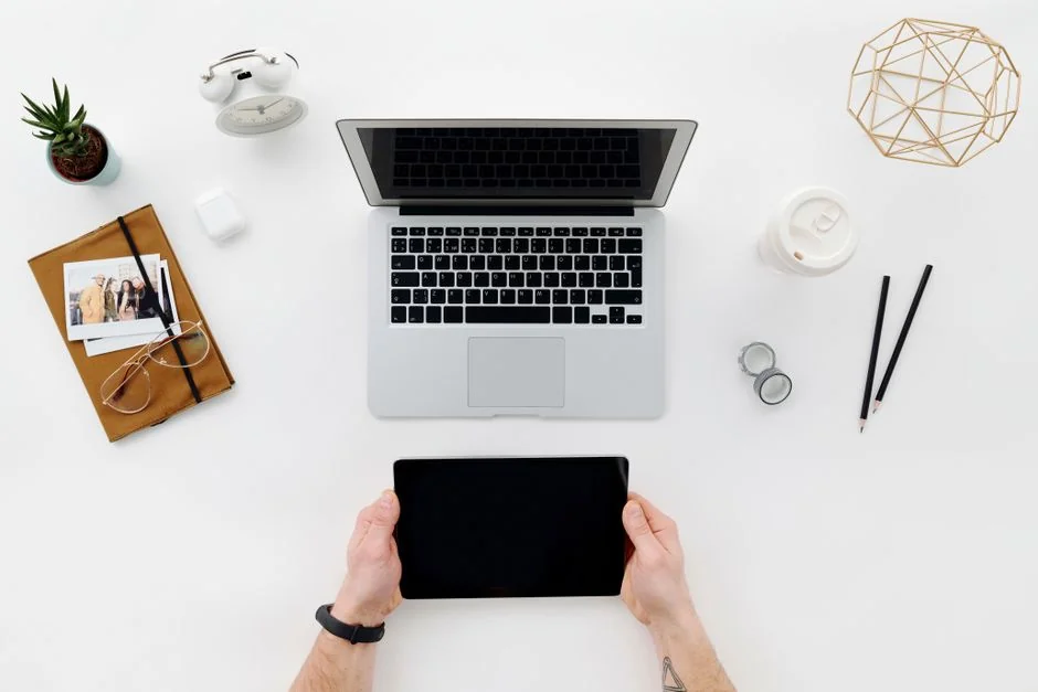 A laptop showing a project management app is placed on a table beside a cozy cup of cappuccino in Amsterdam.